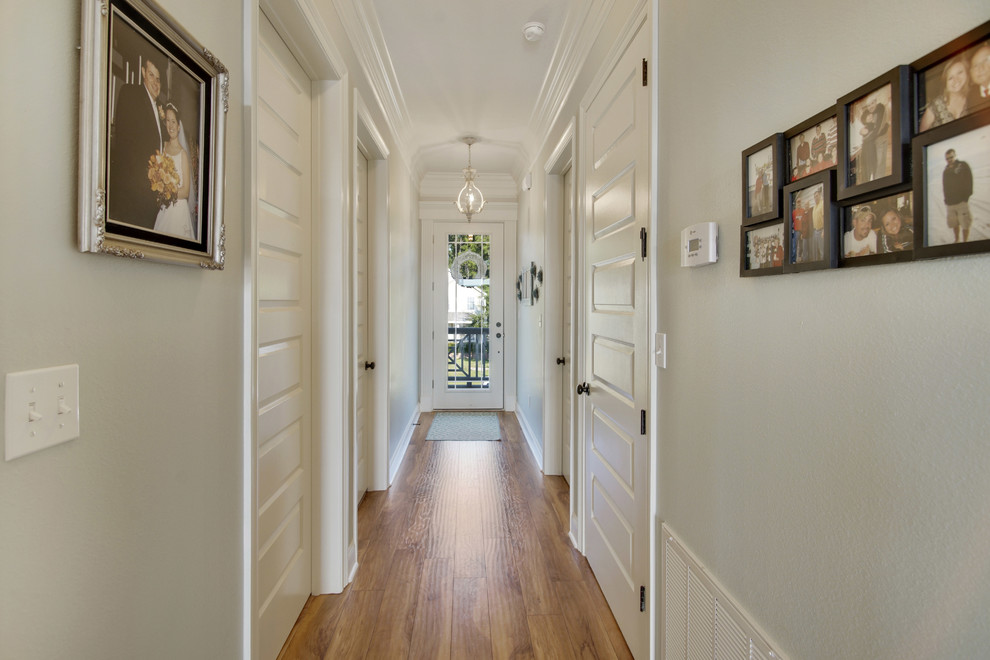 Entryway - mid-sized coastal medium tone wood floor entryway idea in Other with gray walls and a glass front door
