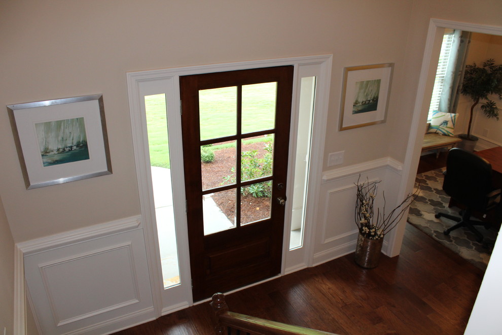 Esempio di un ingresso classico con pareti beige, parquet scuro, una porta singola e una porta in legno scuro