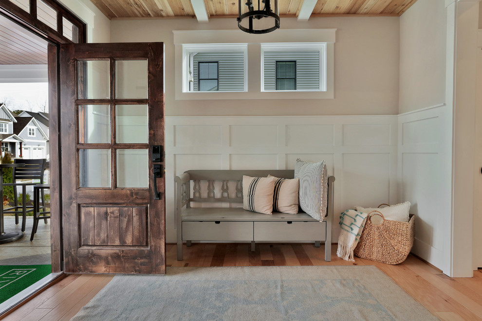 Bild på en lantlig entré, med beige väggar, ljust trägolv, en enkeldörr och beiget golv