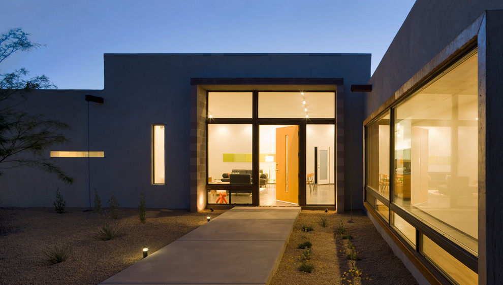 Diseño de entrada minimalista con suelo de cemento y puerta de madera clara
