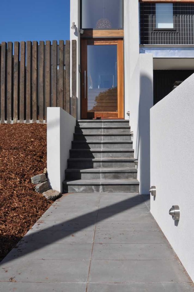 Foto på en mellanstor funkis ingång och ytterdörr, med betonggolv, en enkeldörr, glasdörr, vita väggar och grått golv
