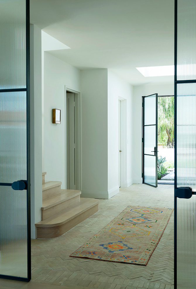 Réalisation d'un hall d'entrée design de taille moyenne avec un mur blanc, tomettes au sol, une porte double et une porte en verre.