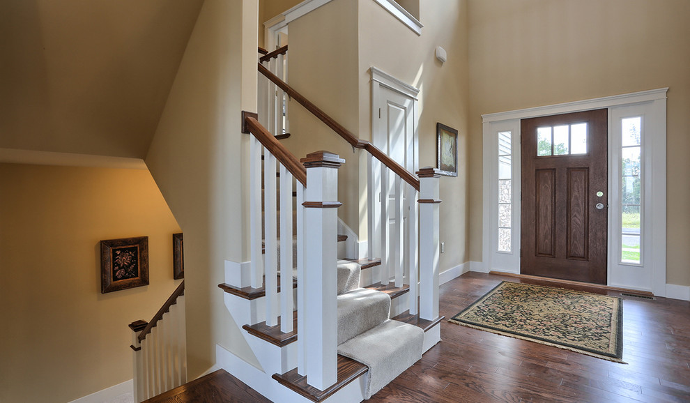 This is an example of a large traditional foyer in Other with beige walls, a dark wood front door, dark hardwood flooring and a single front door.