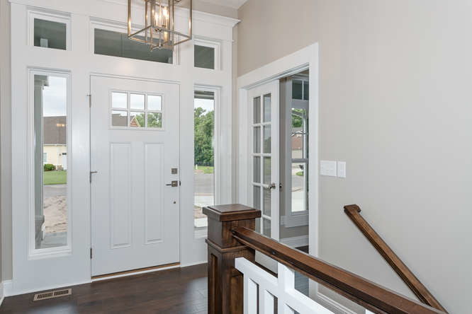 Ispirazione per una porta d'ingresso stile americano di medie dimensioni con pareti grigie, parquet scuro, una porta singola e una porta bianca