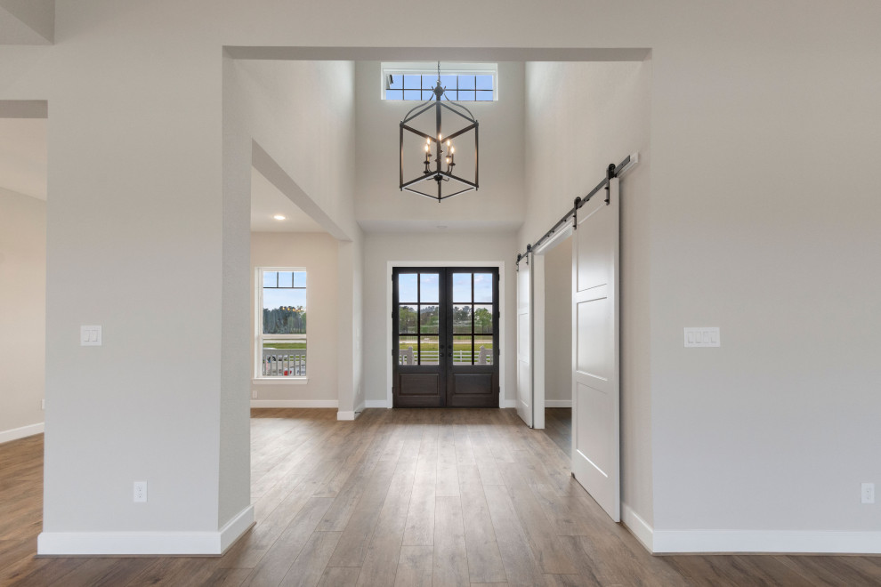 Eingang mit grauer Wandfarbe, Vinylboden, Doppeltür, hellbrauner Holzhaustür und buntem Boden in Houston