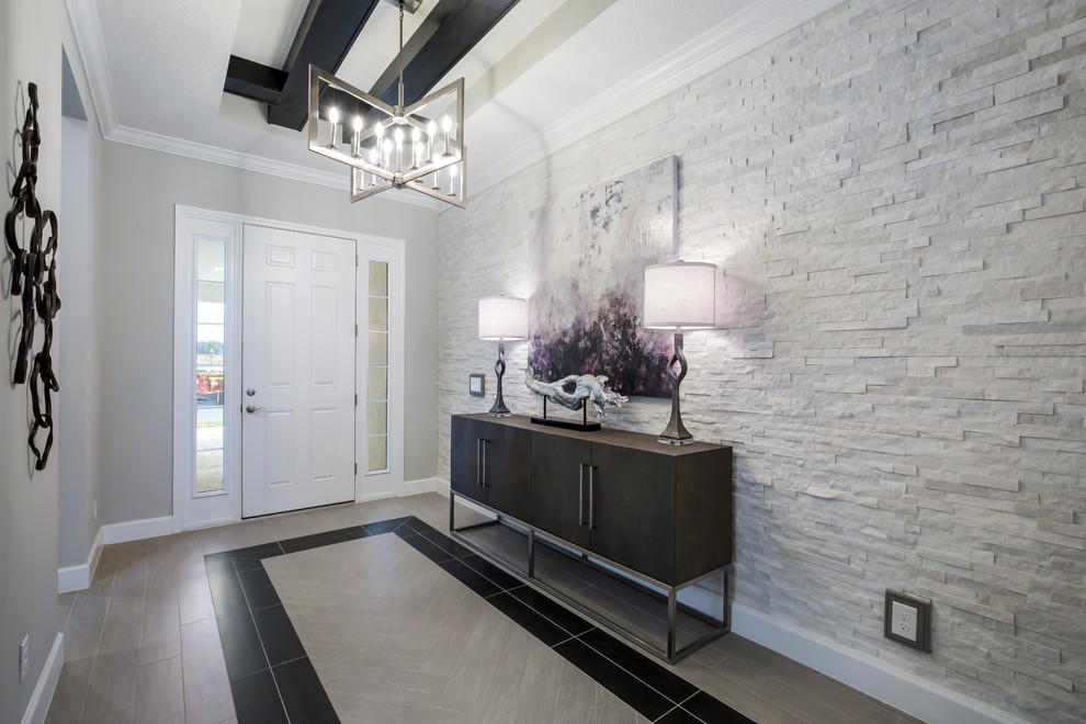Traditional hallway in Orlando with grey walls, a single front door, a white front door, grey floors and feature lighting.