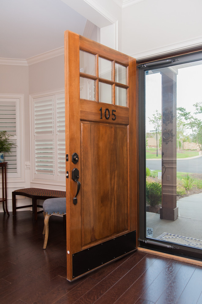 Imagen de puerta principal actual de tamaño medio con paredes blancas, suelo de madera oscura, puerta simple y puerta de madera en tonos medios
