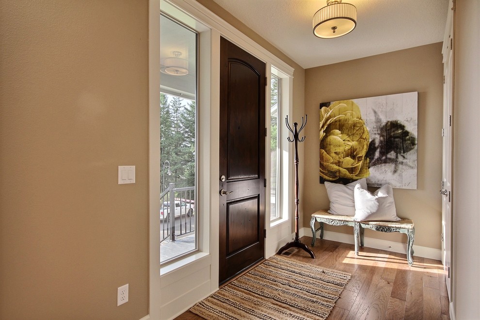 Mid-sized transitional light wood floor entryway photo in Portland with beige walls and a dark wood front door