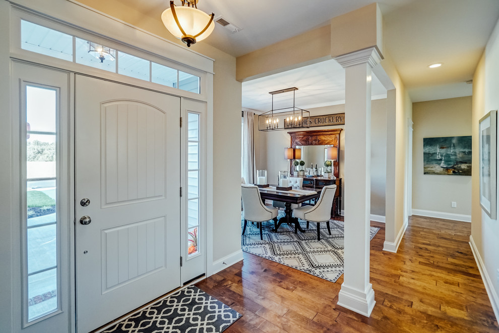 Ejemplo de puerta principal tradicional de tamaño medio con paredes beige, suelo de madera en tonos medios, puerta simple, puerta blanca y suelo marrón