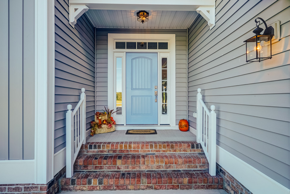 Immagine di una porta d'ingresso classica di medie dimensioni con una porta singola e una porta blu