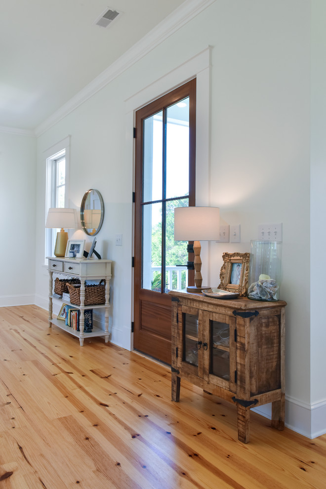 Klassische Haustür mit weißer Wandfarbe, hellem Holzboden, Einzeltür, Haustür aus Glas und braunem Boden in Charleston