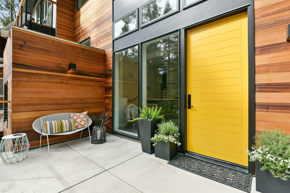 Ejemplo de puerta principal actual con puerta simple y puerta amarilla
