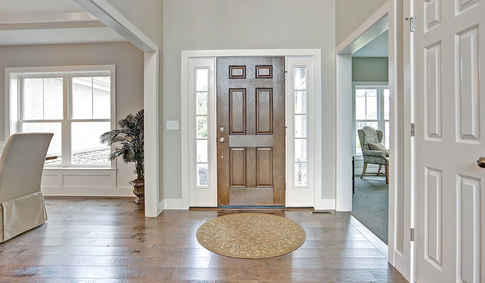 This is an example of a large classic foyer in Other with grey walls, medium hardwood flooring, a single front door and a medium wood front door.