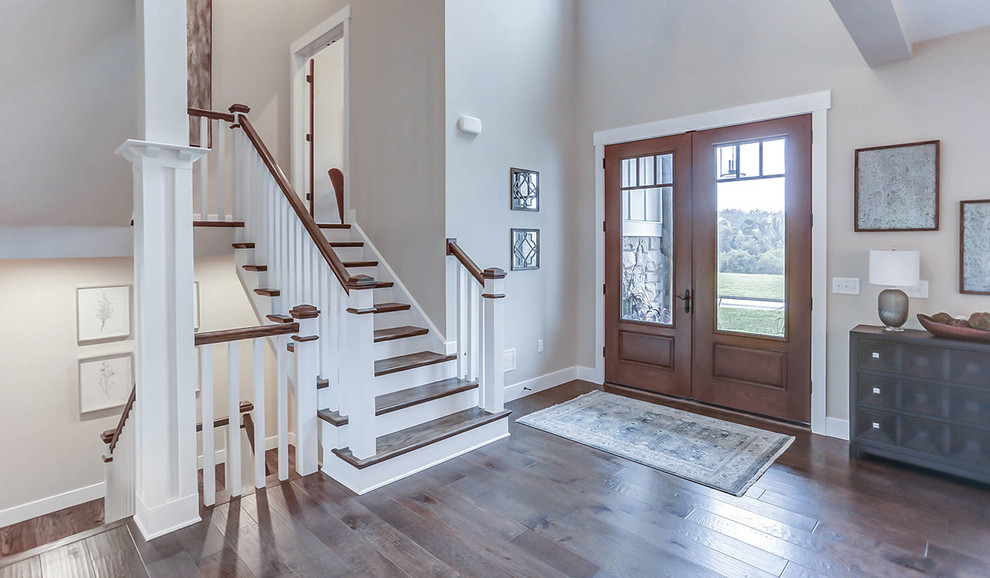 Geräumiges Country Foyer mit grauer Wandfarbe, braunem Holzboden, Doppeltür und hellbrauner Holzhaustür in Sonstige