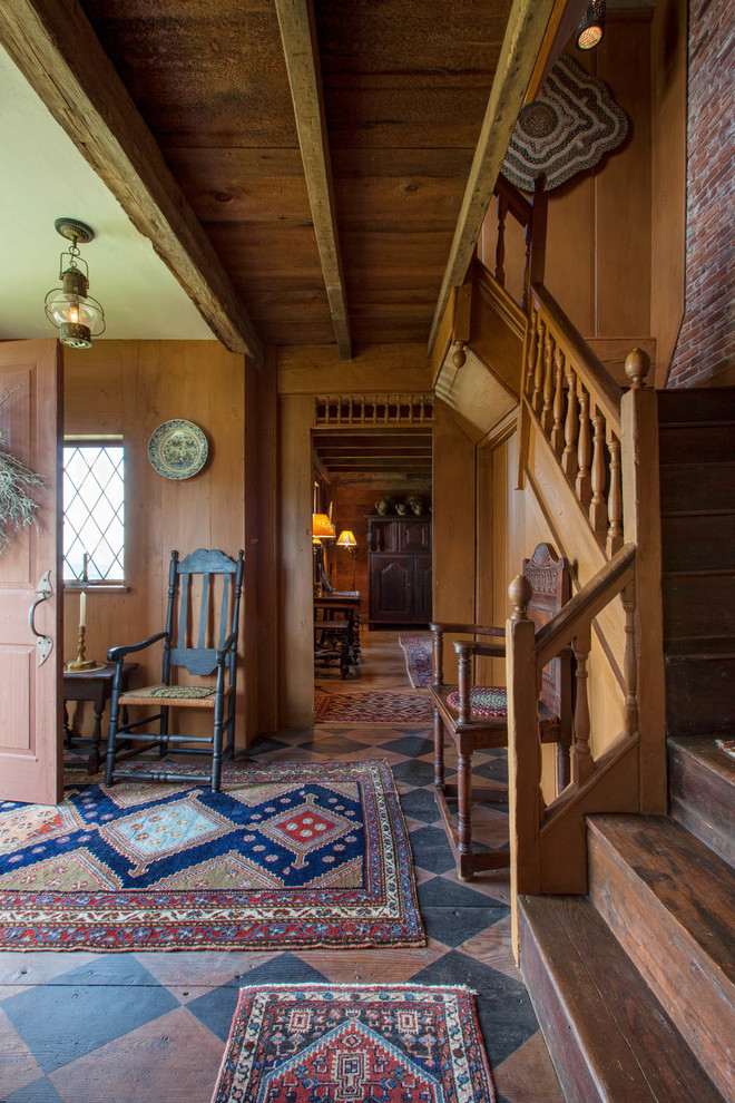 Aménagement d'un hall d'entrée campagne avec une porte en bois foncé, parquet peint et une porte simple.