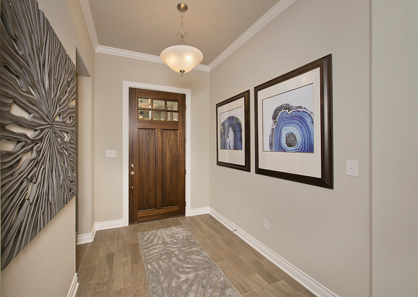 Example of a mid-sized arts and crafts vinyl floor and brown floor entryway design in Houston with gray walls and a dark wood front door