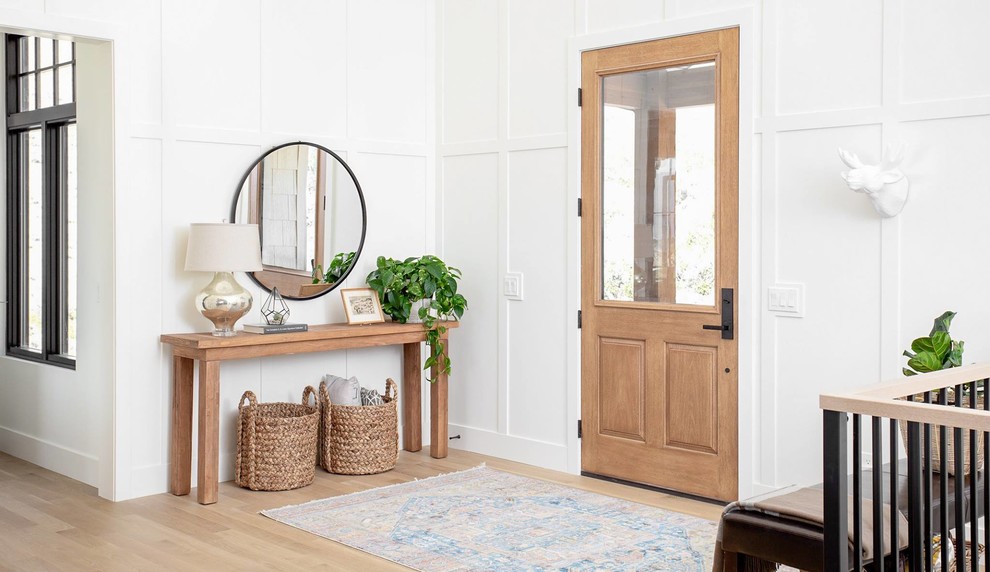 Modelo de distribuidor clásico renovado de tamaño medio con paredes blancas, suelo de madera clara, puerta simple, puerta de madera clara y suelo beige
