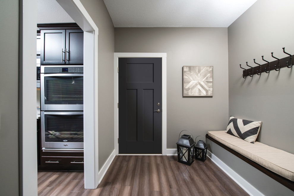 Exempel på ett mellanstort klassiskt kapprum, med grå väggar, mörkt trägolv, en enkeldörr, en svart dörr och brunt golv