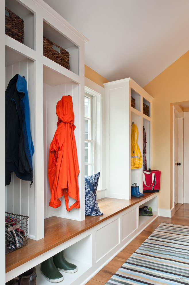 Mudroom - mid-sized contemporary medium tone wood floor mudroom idea in Boston with yellow walls