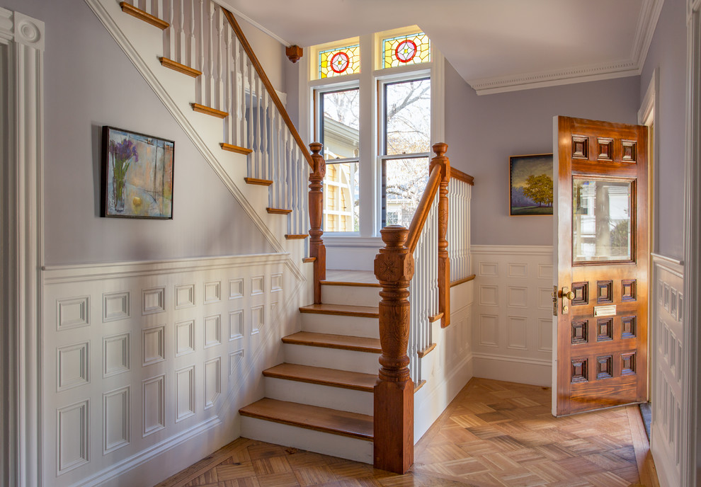 Design ideas for a victorian foyer in Boston with purple walls, medium hardwood flooring, a single front door, a dark wood front door and a dado rail.