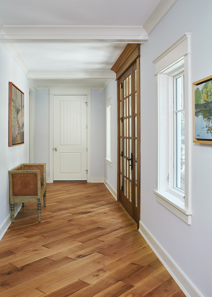 На фото: узкая прихожая в классическом стиле с серыми стенами, паркетным полом среднего тона, одностворчатой входной дверью, входной дверью из дерева среднего тона и синим полом