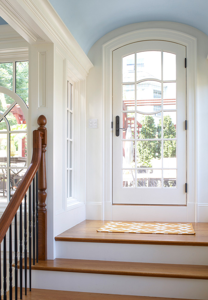 ボストンにある中くらいなヴィクトリアン調のおしゃれな玄関ラウンジ (白い壁、淡色無垢フローリング、白いドア) の写真