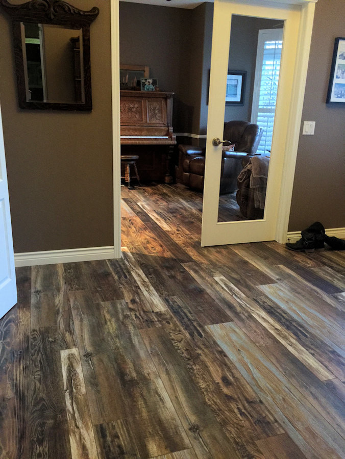 Mid-sized mountain style painted wood floor entryway photo in Calgary with brown walls and a white front door