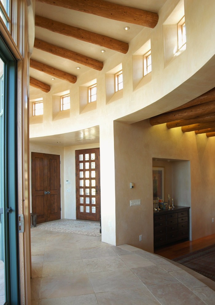 Foto di un ingresso o corridoio stile americano di medie dimensioni con pareti marroni, pavimento in travertino e pavimento marrone