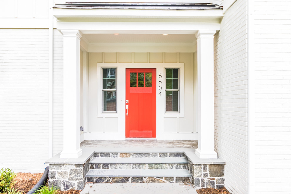 На фото: огромная входная дверь в стиле кантри с одностворчатой входной дверью и красной входной дверью