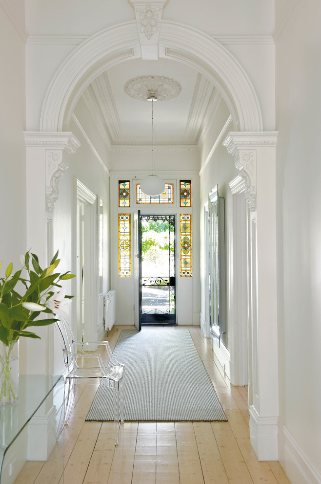 Пример оригинального дизайна: узкая прихожая: освещение в классическом стиле с белыми стенами, светлым паркетным полом, одностворчатой входной дверью и металлической входной дверью