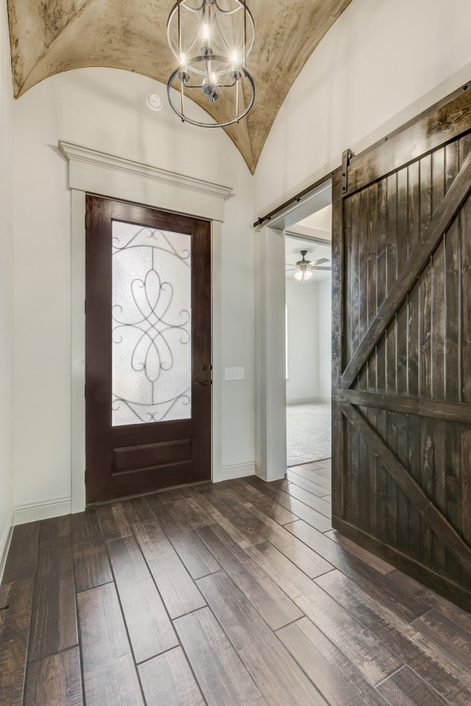 Idée de décoration pour une petite entrée champêtre avec un couloir, un mur blanc, parquet foncé, une porte simple, une porte en verre et un sol marron.