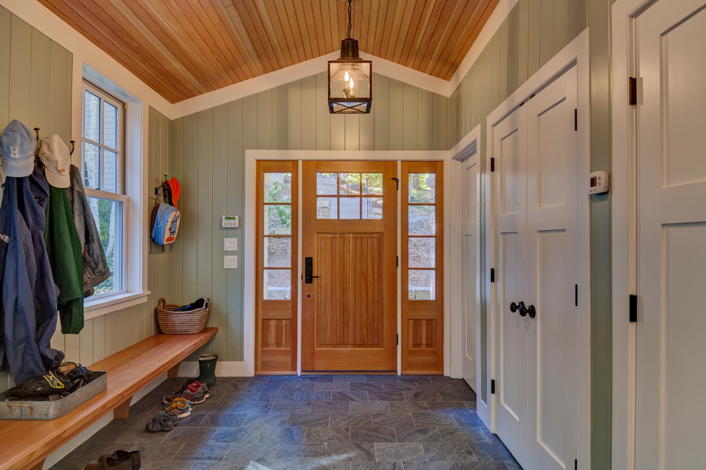 Aménagement d'une entrée classique de taille moyenne avec un vestiaire, un mur vert, un sol en ardoise, une porte simple et une porte en bois clair.