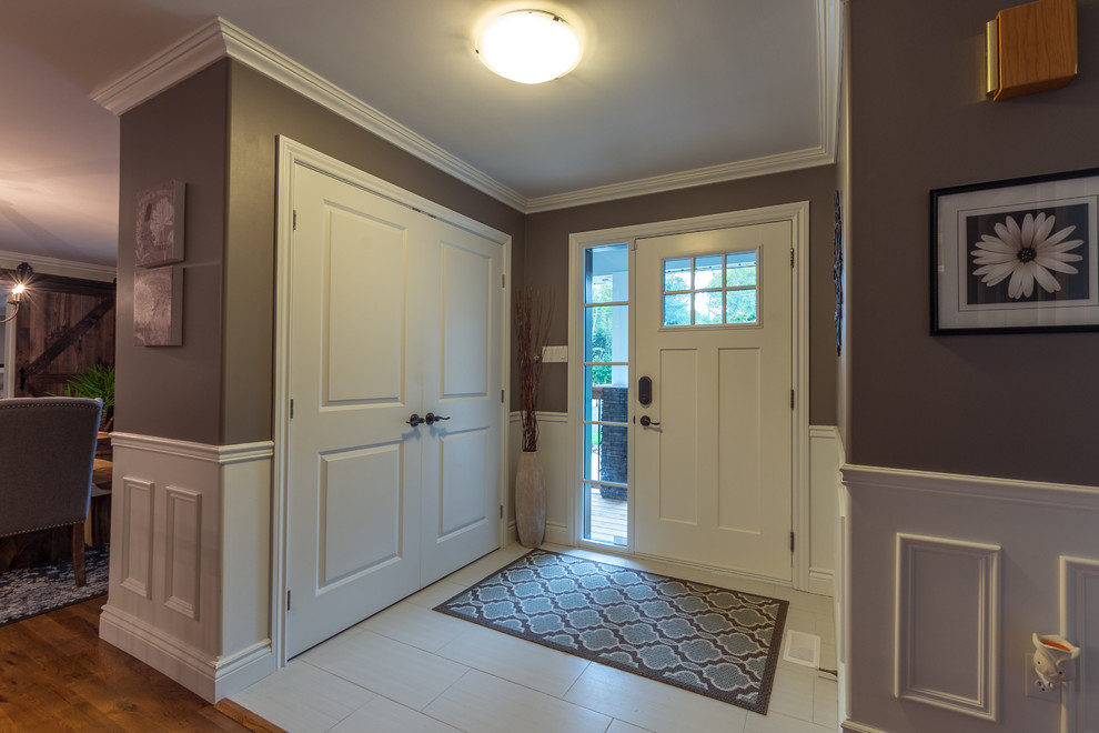 На фото: вестибюль среднего размера в классическом стиле с серыми стенами, полом из керамогранита, одностворчатой входной дверью, белой входной дверью и белым полом с