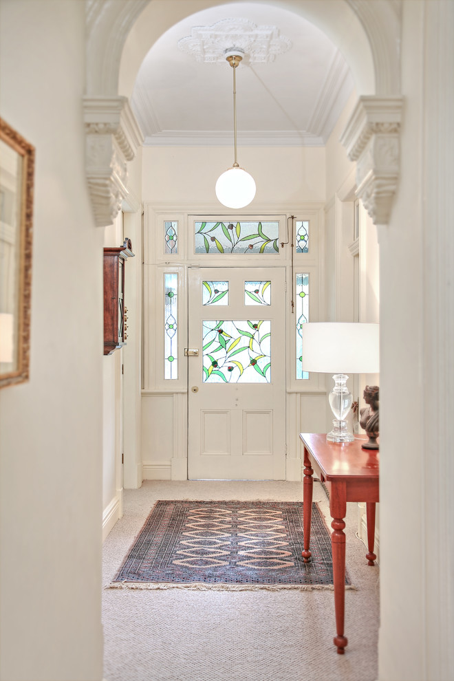 Идея дизайна: большая узкая прихожая в классическом стиле с белыми стенами, ковровым покрытием, бежевым полом, одностворчатой входной дверью и белой входной дверью