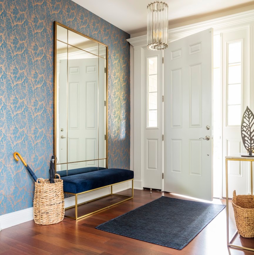 Aménagement d'une porte d'entrée classique de taille moyenne avec un mur bleu, parquet foncé, une porte simple, une porte blanche et un sol marron.