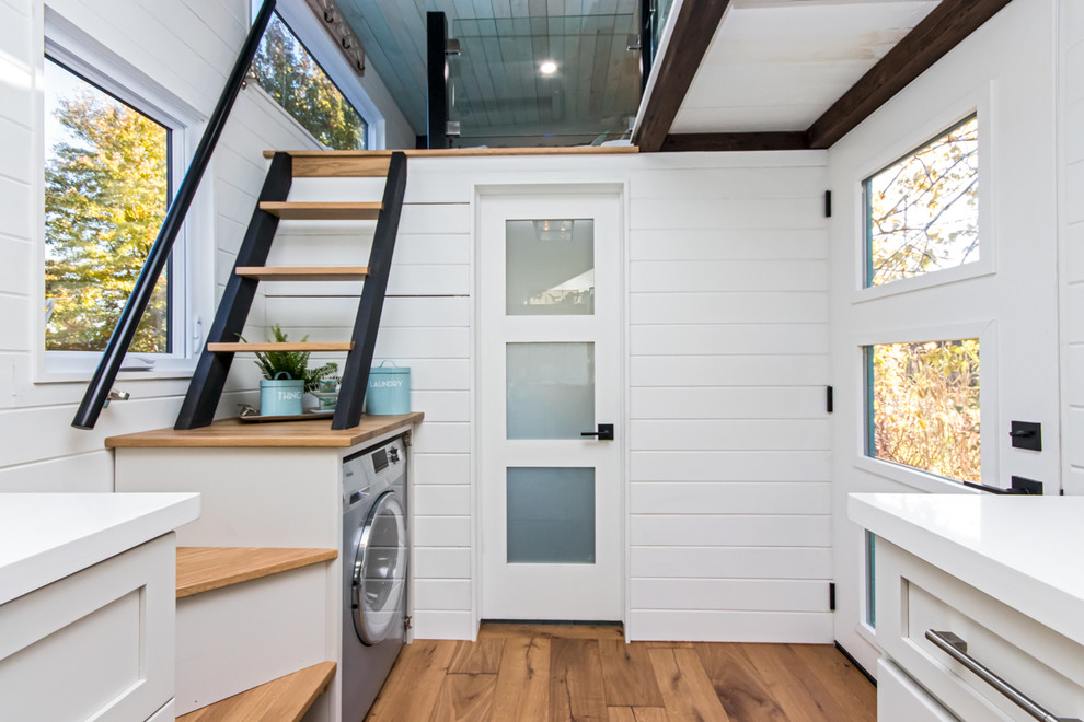 Diseño de distribuidor marinero pequeño con paredes blancas, suelo de madera en tonos medios, puerta simple, puerta blanca y suelo marrón