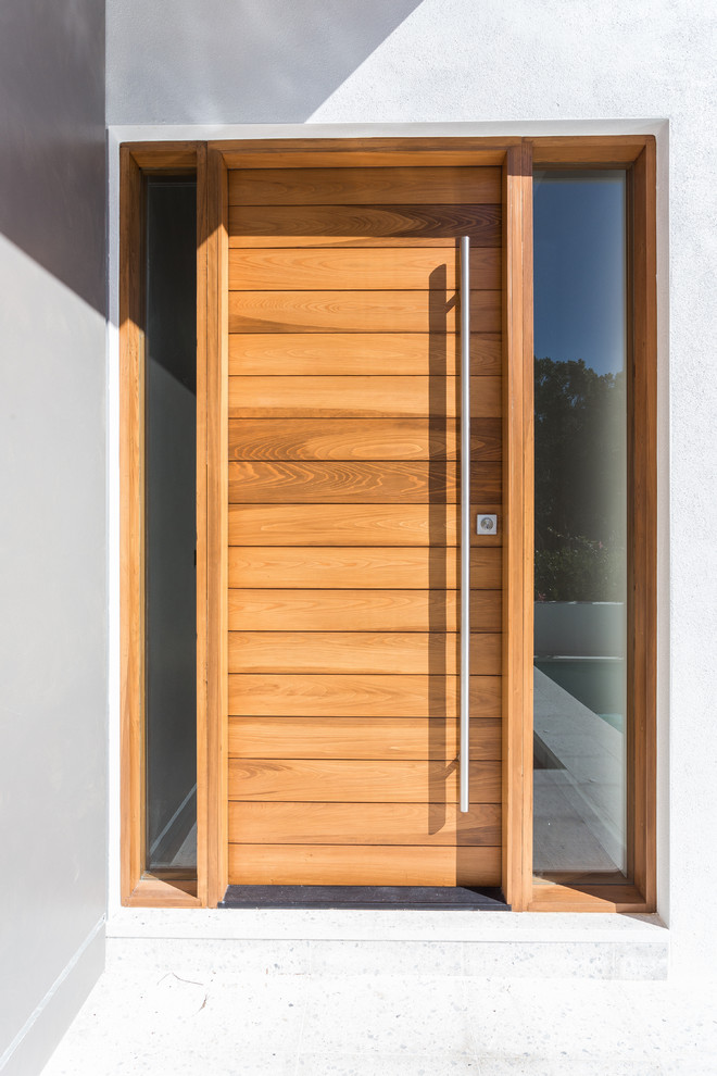 Ejemplo de puerta principal actual de tamaño medio con paredes blancas, suelo de cemento, puerta simple y puerta marrón
