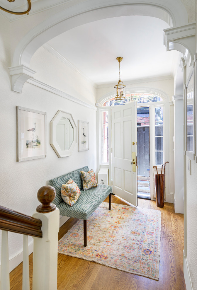 Klassischer Eingang mit weißer Wandfarbe, braunem Holzboden, Einzeltür, weißer Haustür und braunem Boden in Boston