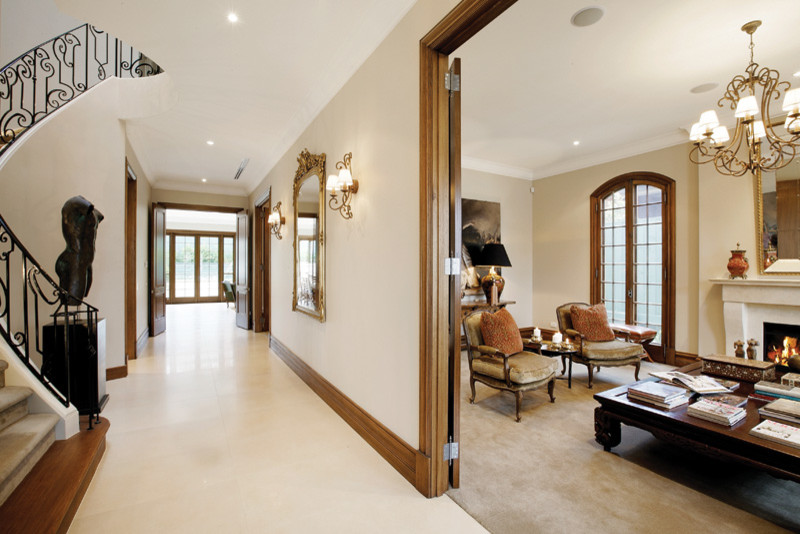 Стильный дизайн: узкая прихожая в классическом стиле с бежевыми стенами, мраморным полом, двустворчатой входной дверью и металлической входной дверью - последний тренд