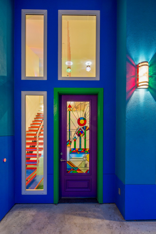 Example of an eclectic entryway design in Austin with a glass front door