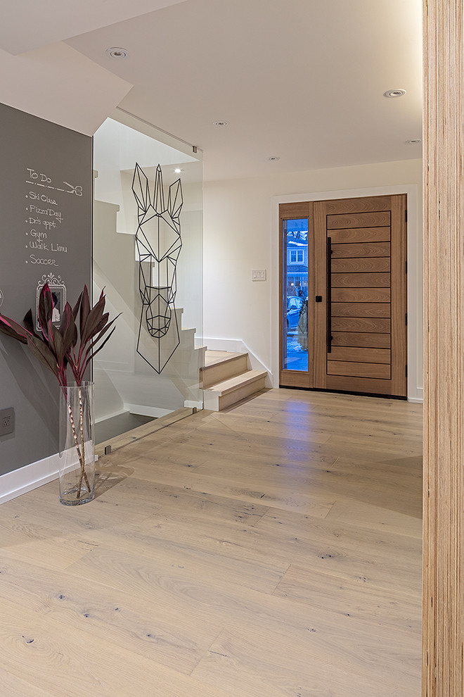 Foto de hall contemporáneo pequeño con paredes blancas, suelo de madera clara, puerta simple, puerta de madera en tonos medios y suelo beige