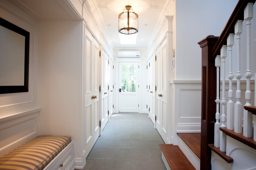 Aménagement d'une entrée classique avec un vestiaire, un mur blanc, un sol en ardoise, une porte simple, une porte blanche et un sol vert.