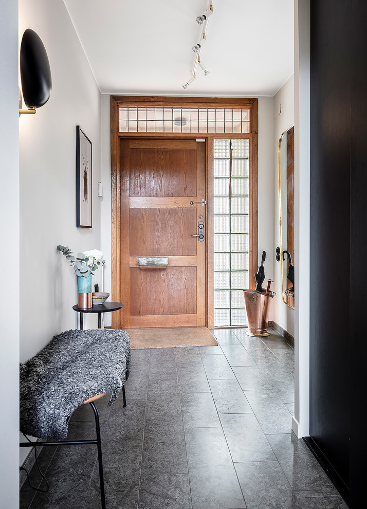 Idee per una porta d'ingresso scandinava di medie dimensioni con pareti beige, pavimento in pietra calcarea, una porta singola, una porta in legno bruno e pavimento grigio