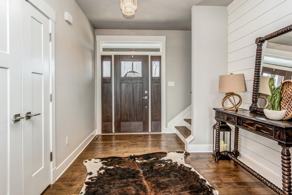 Entryway - mid-sized farmhouse medium tone wood floor and brown floor entryway idea in Other with gray walls and a medium wood front door