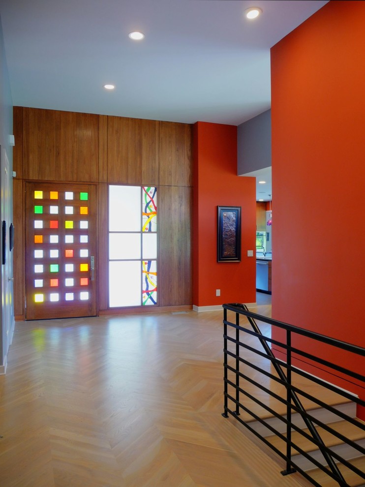 Idee per una porta d'ingresso moderna di medie dimensioni con pareti rosse, parquet chiaro, una porta a pivot e una porta in legno scuro