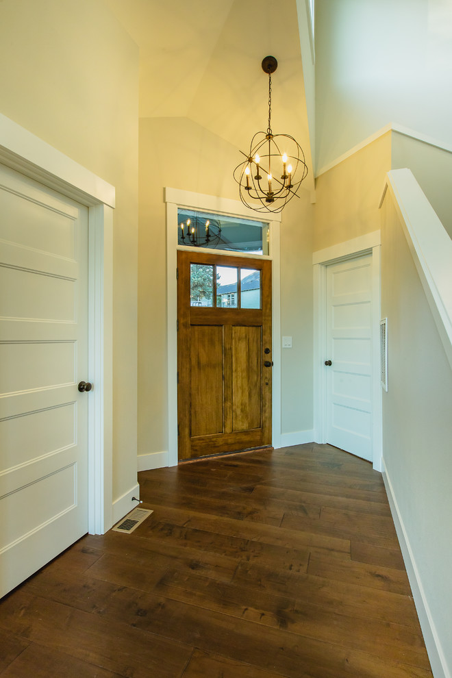 На фото: маленькая входная дверь в стиле кантри с бежевыми стенами, темным паркетным полом, одностворчатой входной дверью, входной дверью из дерева среднего тона и коричневым полом для на участке и в саду с