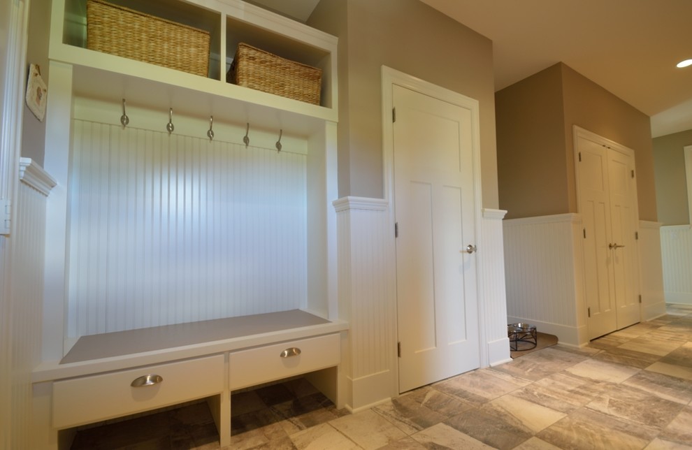 Example of a mid-sized classic porcelain tile mudroom design in New York with beige walls