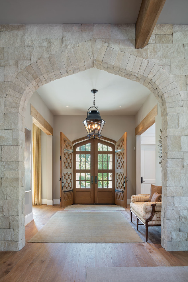 Klassisches Foyer mit grauer Wandfarbe, braunem Holzboden, Doppeltür und hellbrauner Holzhaustür in Houston