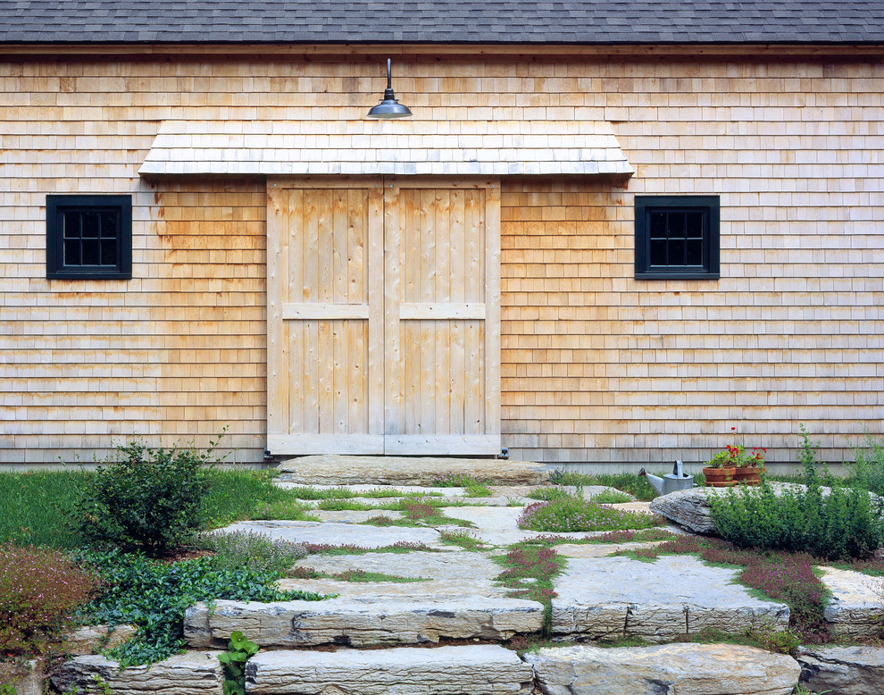 Immagine di un ingresso o corridoio country con una porta scorrevole e una porta in legno bruno