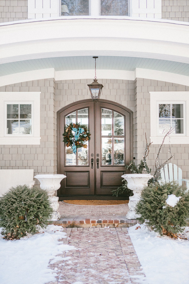 Klassische Haustür mit beiger Wandfarbe, Backsteinboden, Doppeltür, brauner Haustür und rotem Boden in Minneapolis